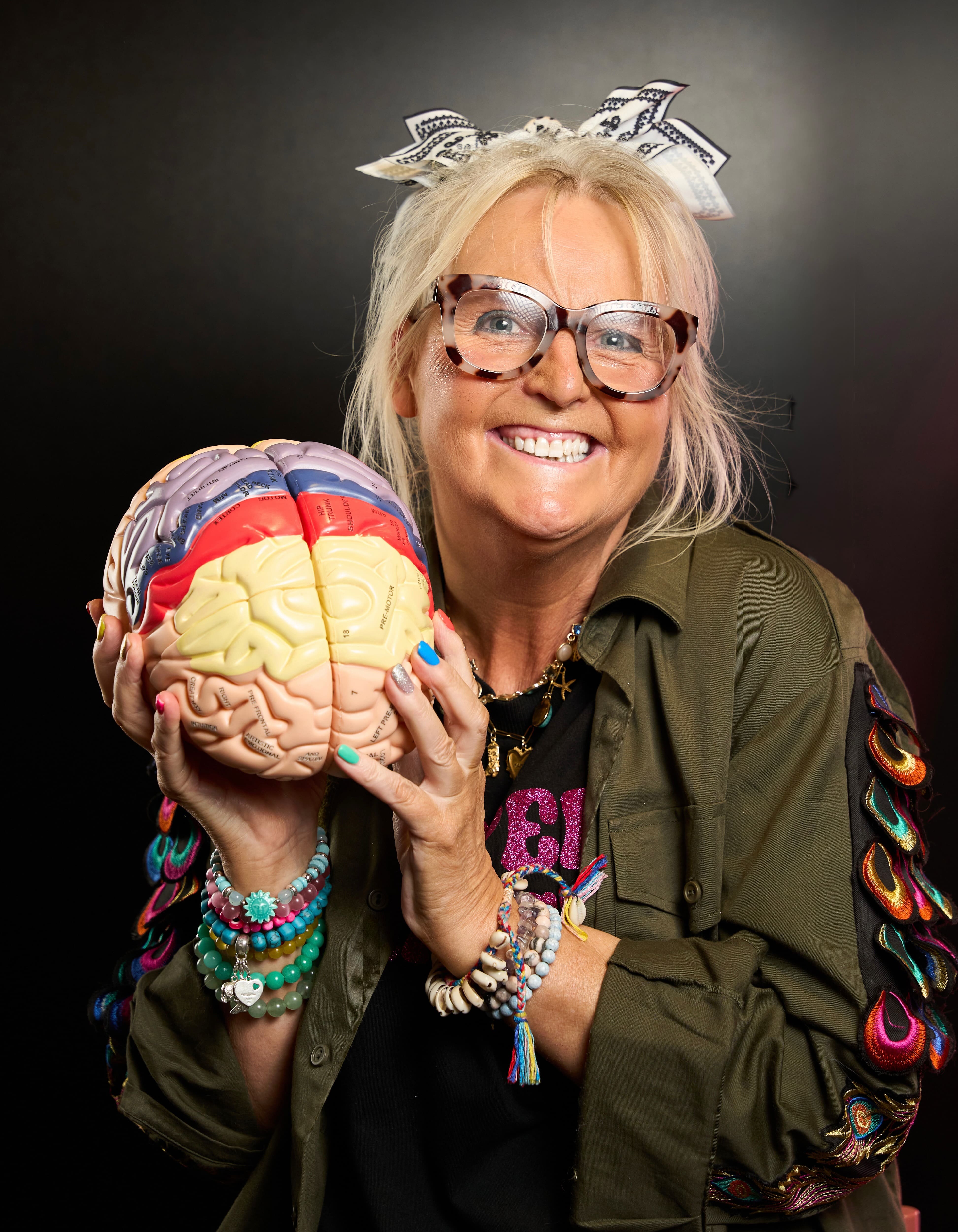 Jules Mitchell holding a colourful model brain, her Internal Operating System